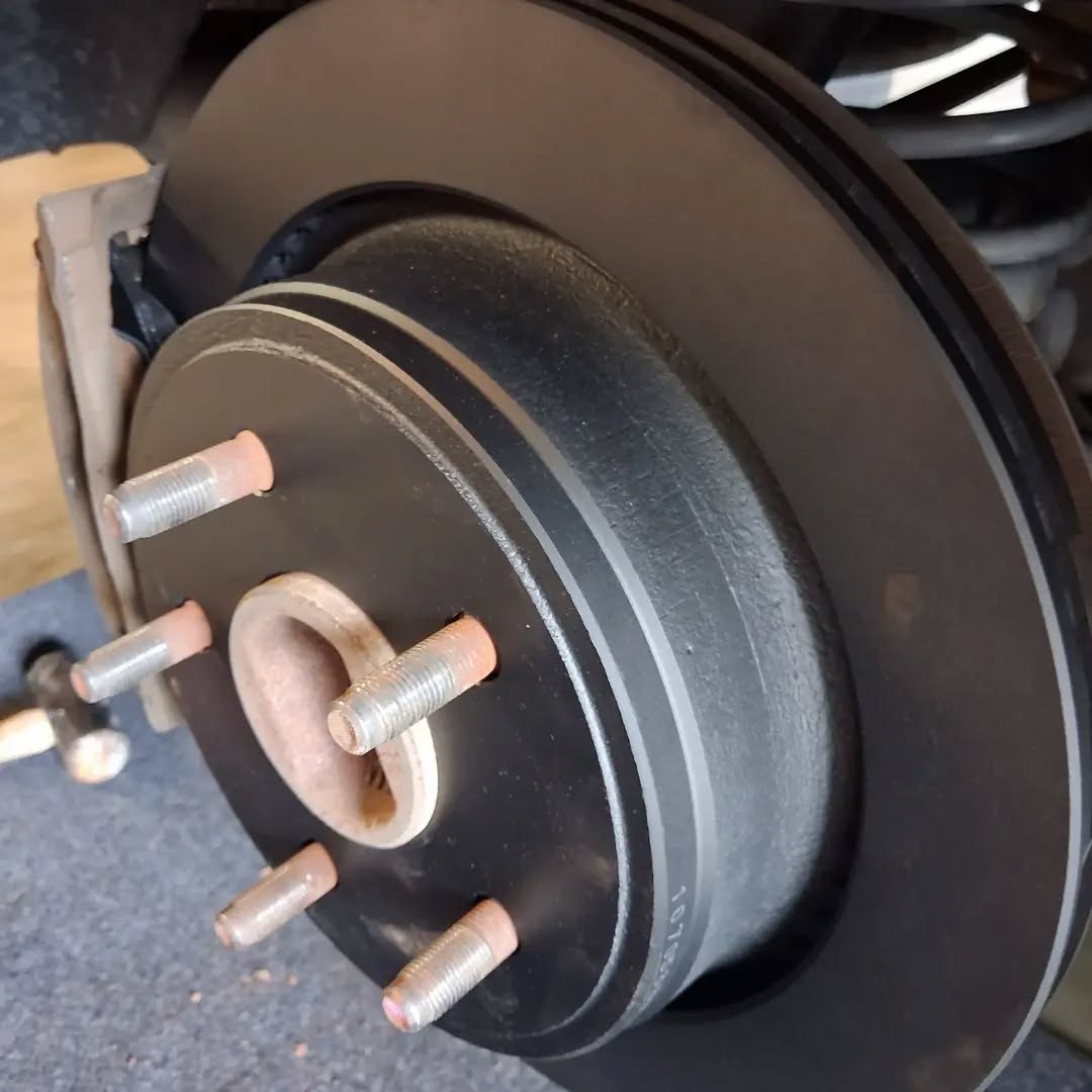 New brake rotor mounted on a wheel hub during a mobile brake job