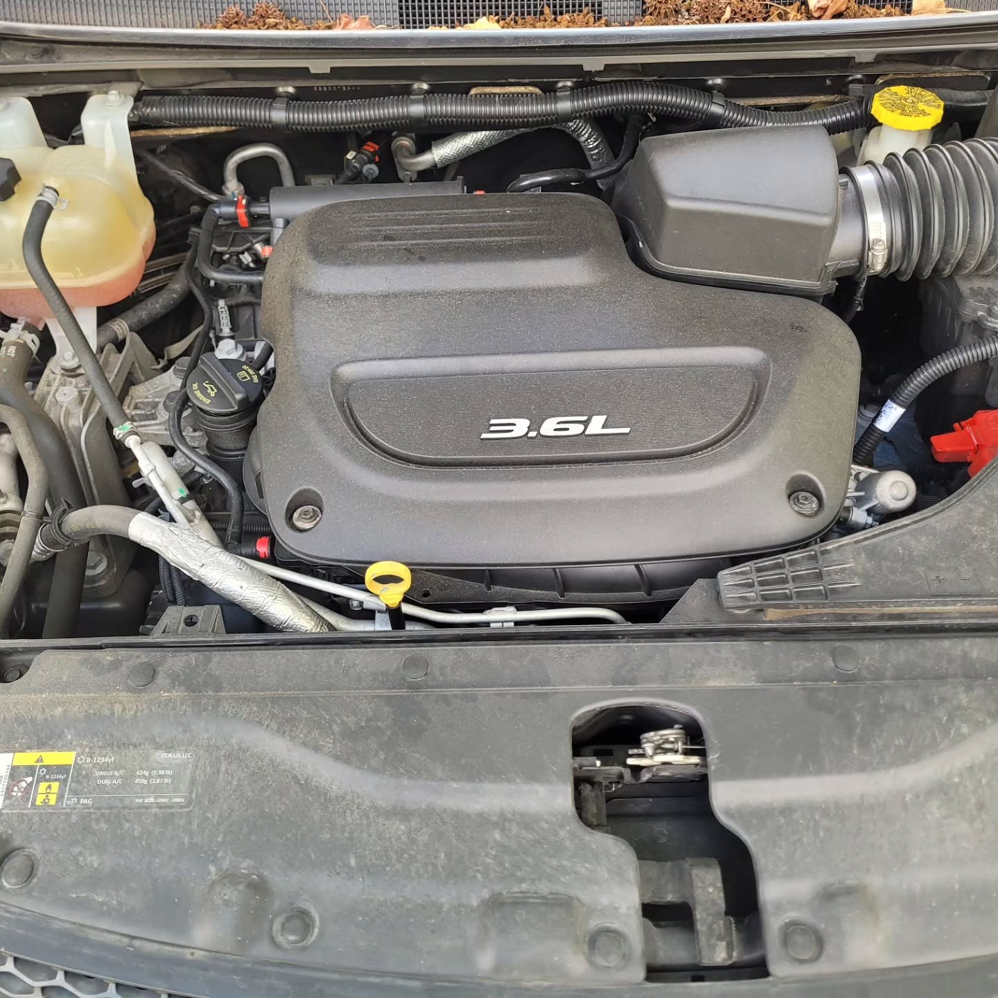Chrysler Pacifica 3.6L engine bay opened up for service in a customer's driveway