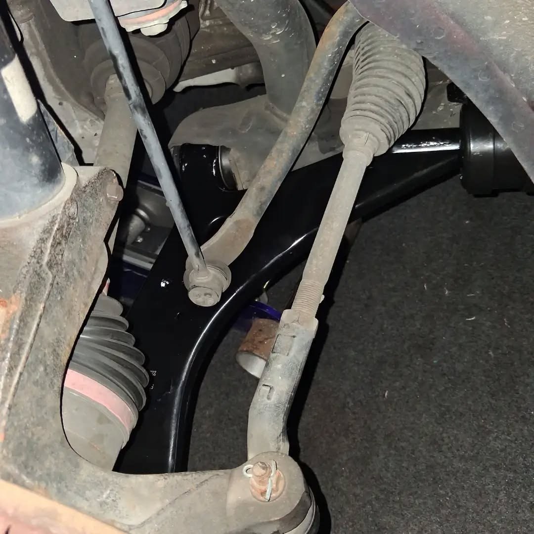 New black lower control arm installed under a car
