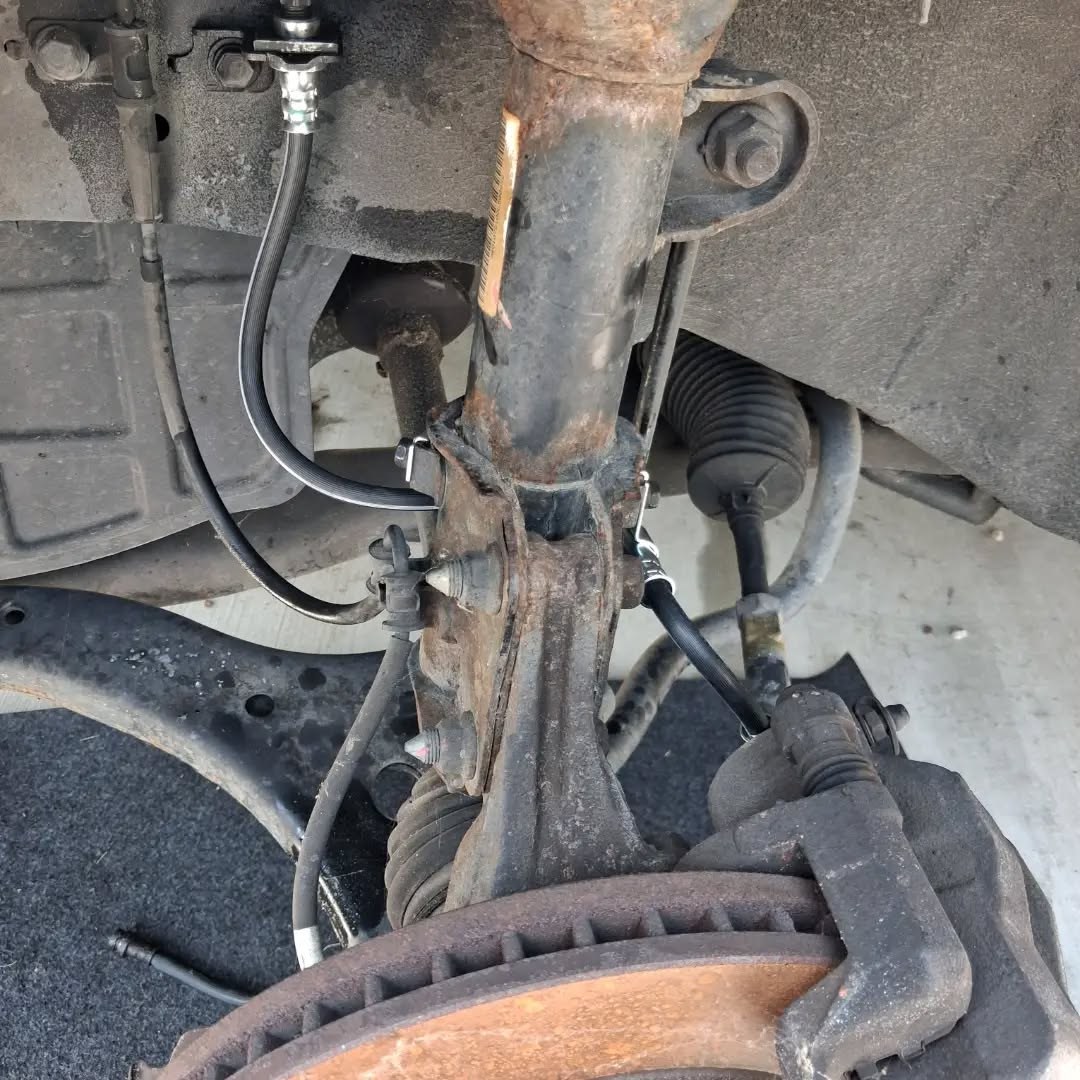Strut and steering knuckle assembly exposed with the wheel removed