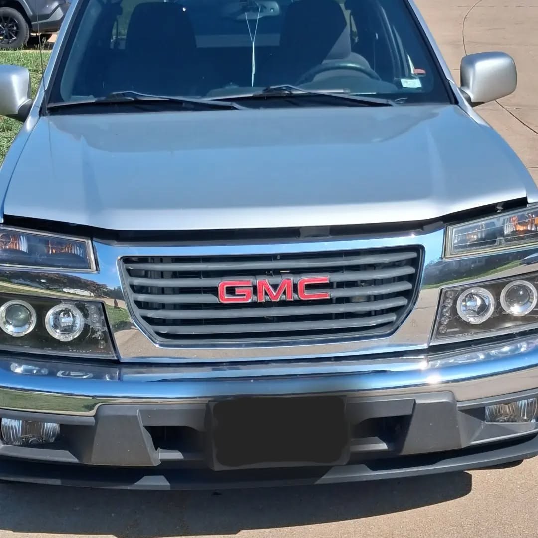 Front grille of a silver GMC Canyon pickup parked on a driveway