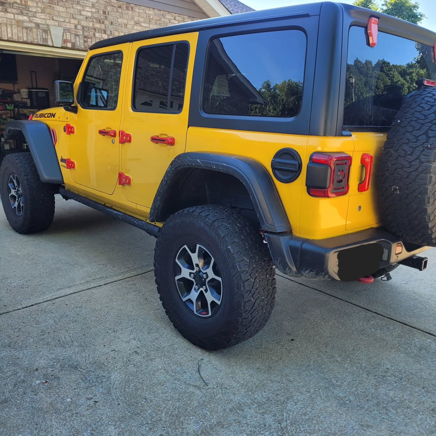 Yellow Jeep Wrangler Rubicon parked on a driveway after an auxiliary battery replacement