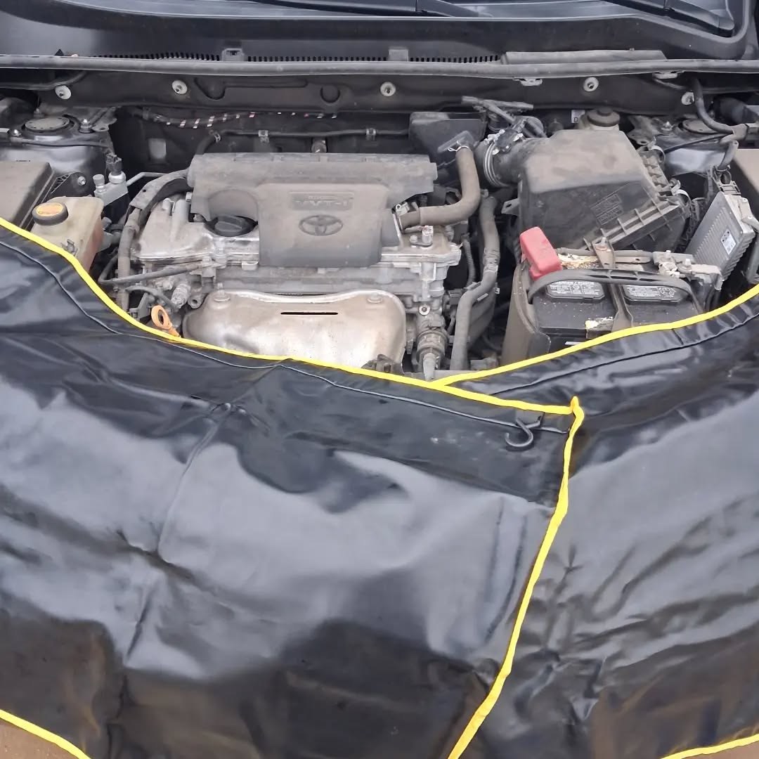 Toyota RAV4 engine bay with a protective fender cover laid over the paint