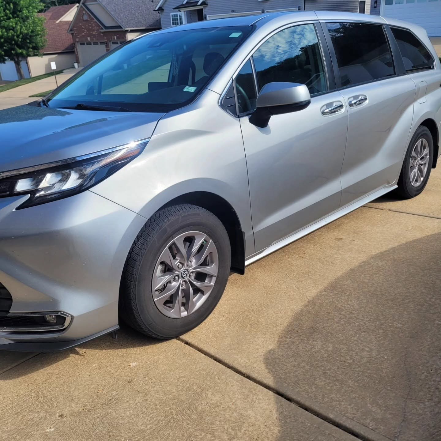 Silver Toyota Sienna minivan parked on a concrete driveway